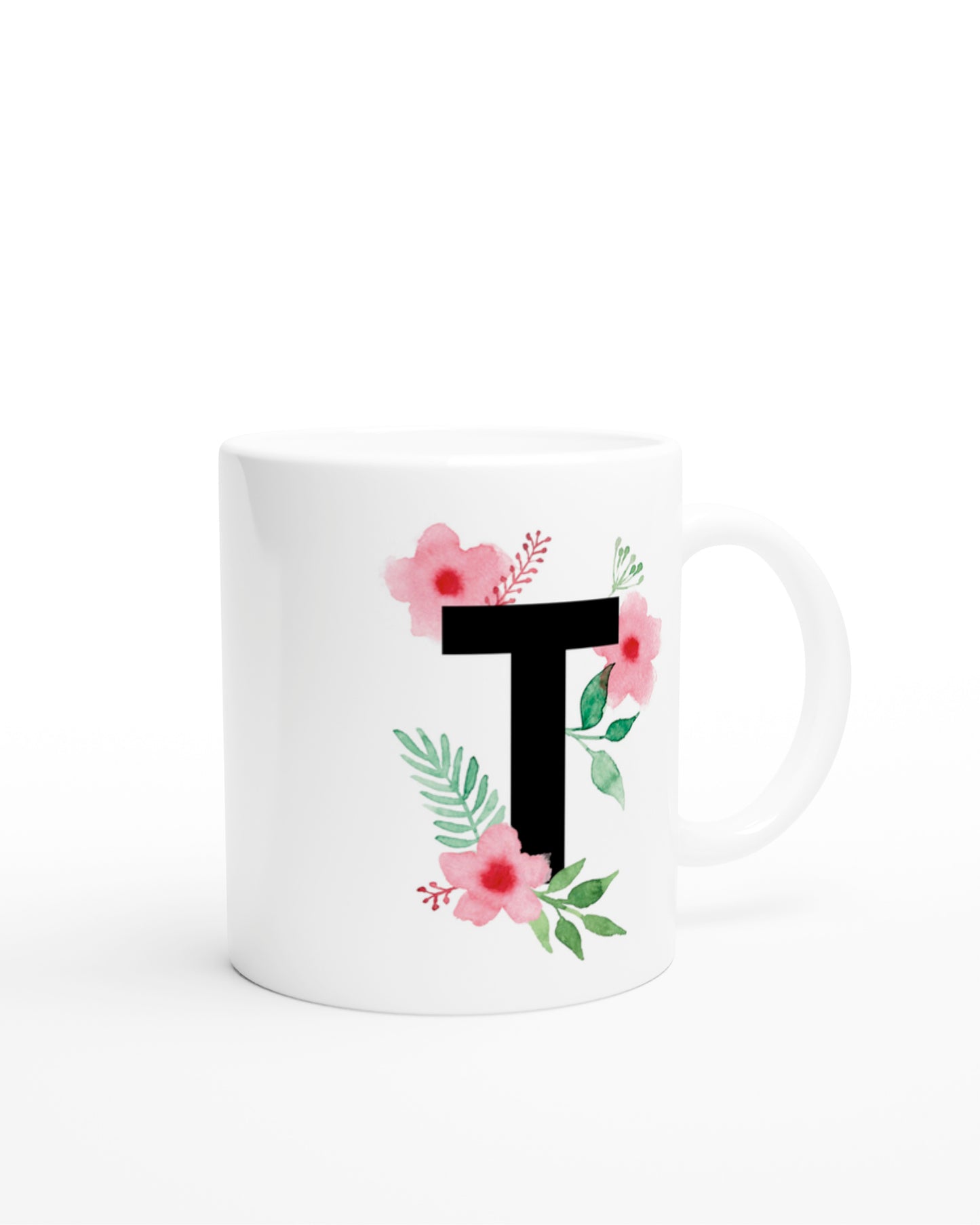 Weiße Keramiktasse mit schwarzem Buchstaben T und rosa-grünen Aquarell-Blumen