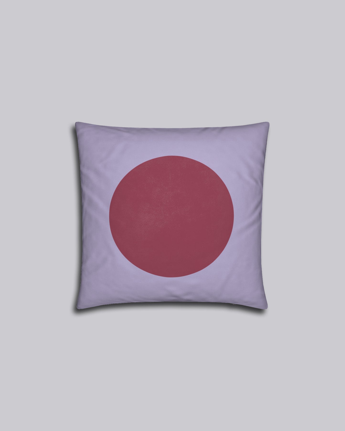 Das Kissen Red Dot auf grauem Hintergrund.