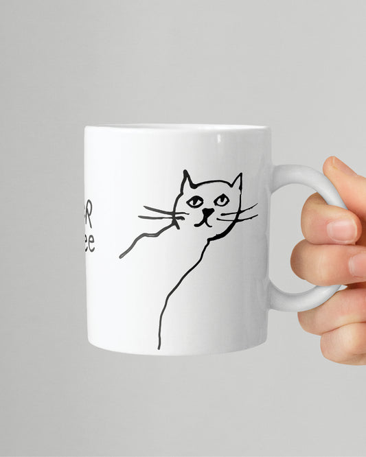 Eine Hand hält die Kater Kaffee Tasse vor einem grauen Hintergrund