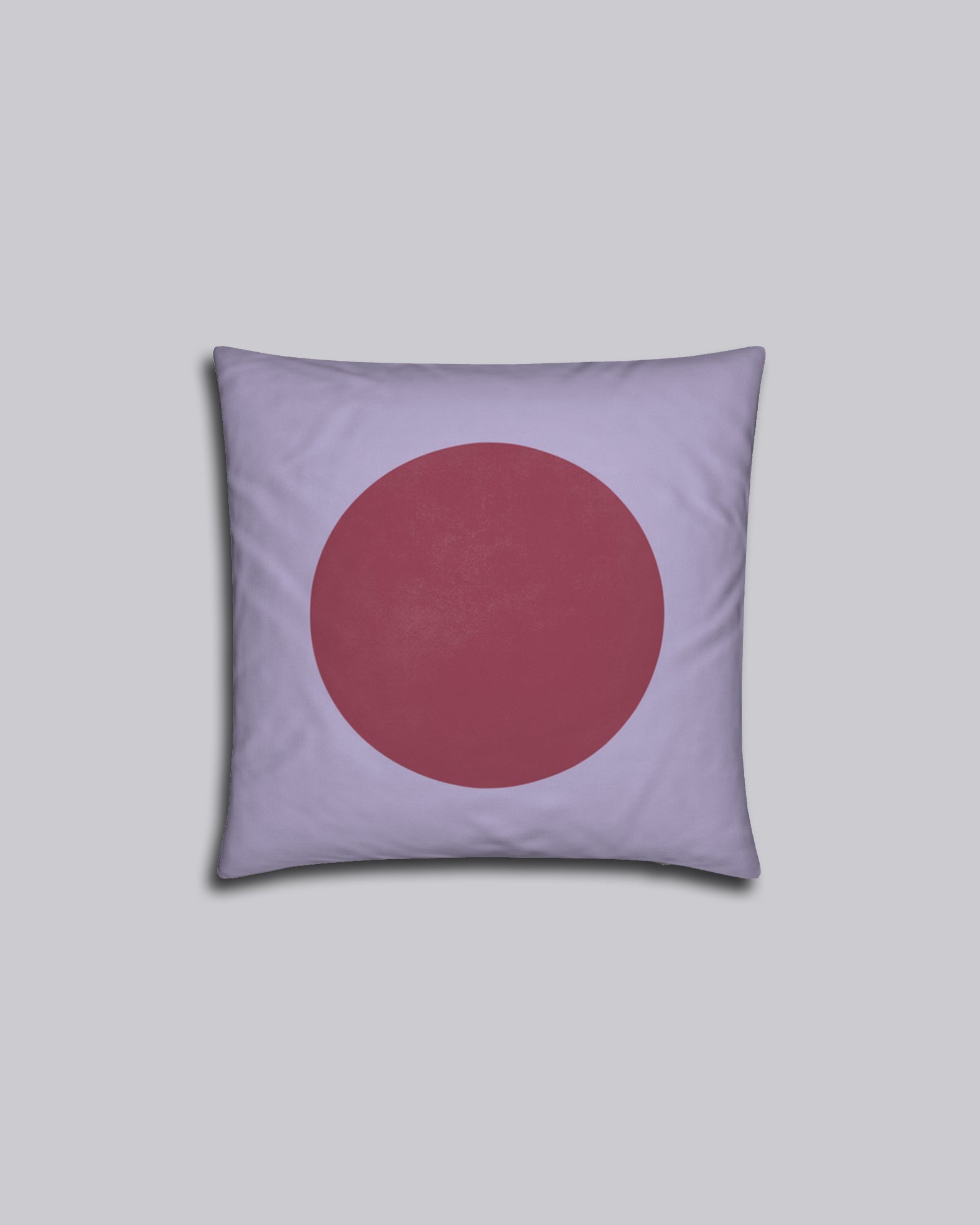 Das Kissen Red Dot auf grauem Hintergrund.
