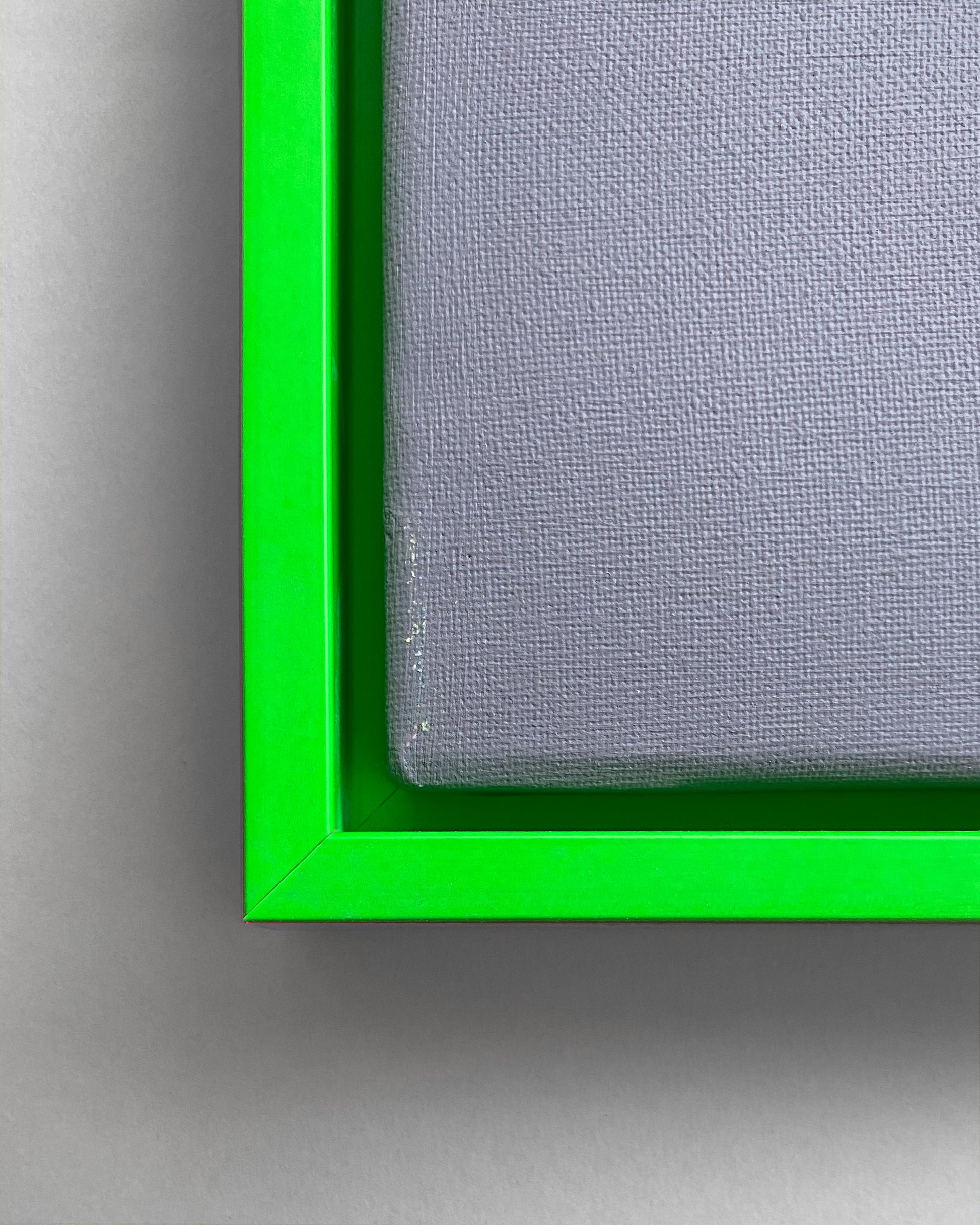 Detail des Schattenfugen-Rahmens in Neon Grün mit einer grauen Leinwand