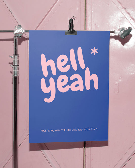 Blaues Typografie-Poster „hell yeah“ vor rosa Tür in modernem Interior-Setting.