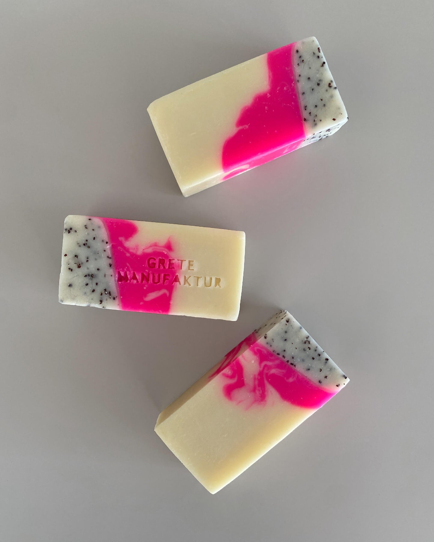 Drei Seifenstücke "Saskia" mehrfarbig: Creme, Neonpink und schwarz gesprenkelt.