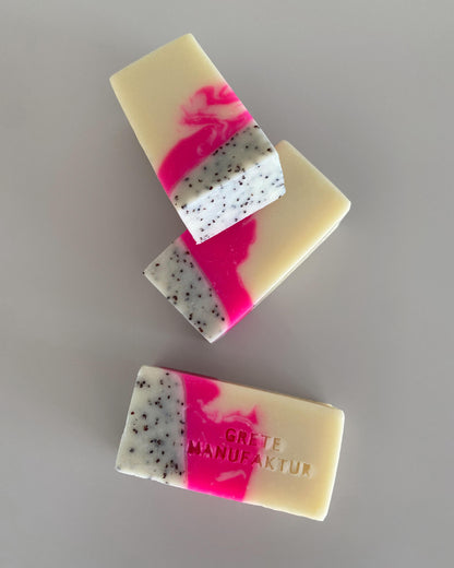 Drei Seifenstücke mit hochwertig handgemachter Haptik und einer dreifachen Farbgebung: Neonpink, Creme und schwarz gesprenkelt. Mit Buchstabenprägung auf einer Seife: Grete Manufaktur