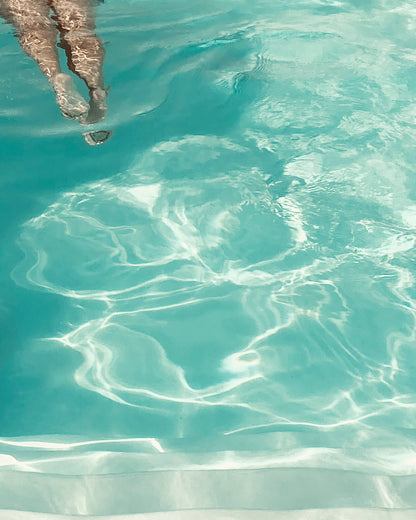 Detailausschnitt des Posters The Pool Girl - Wellenstruktur und Beine einer Frau im Anschnitt